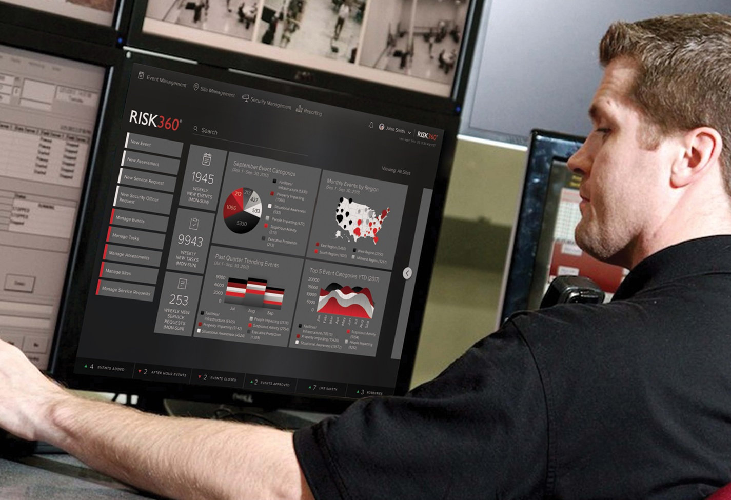 Security officer working at a desk with multiple computer screens. His back is to the camera.