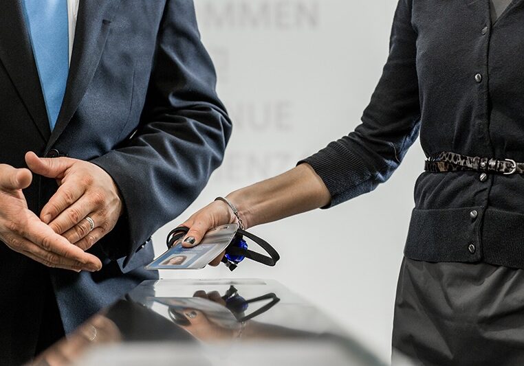 Woman scanning access badge and man beside her checking for access