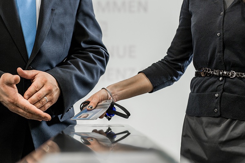 Woman scanning access badge and man beside her checking for access