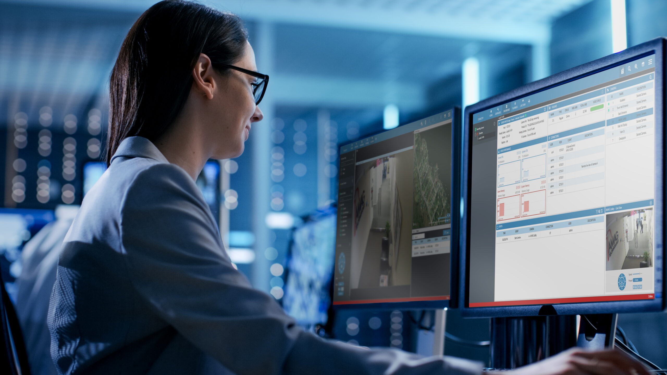 Close-up Shot of Female IT Engineer Working in Monitoring Room. She Works with Multiple Displays.