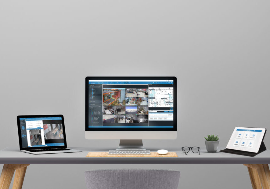 Desk with a laptop, desktop computer, and tablet all open for work