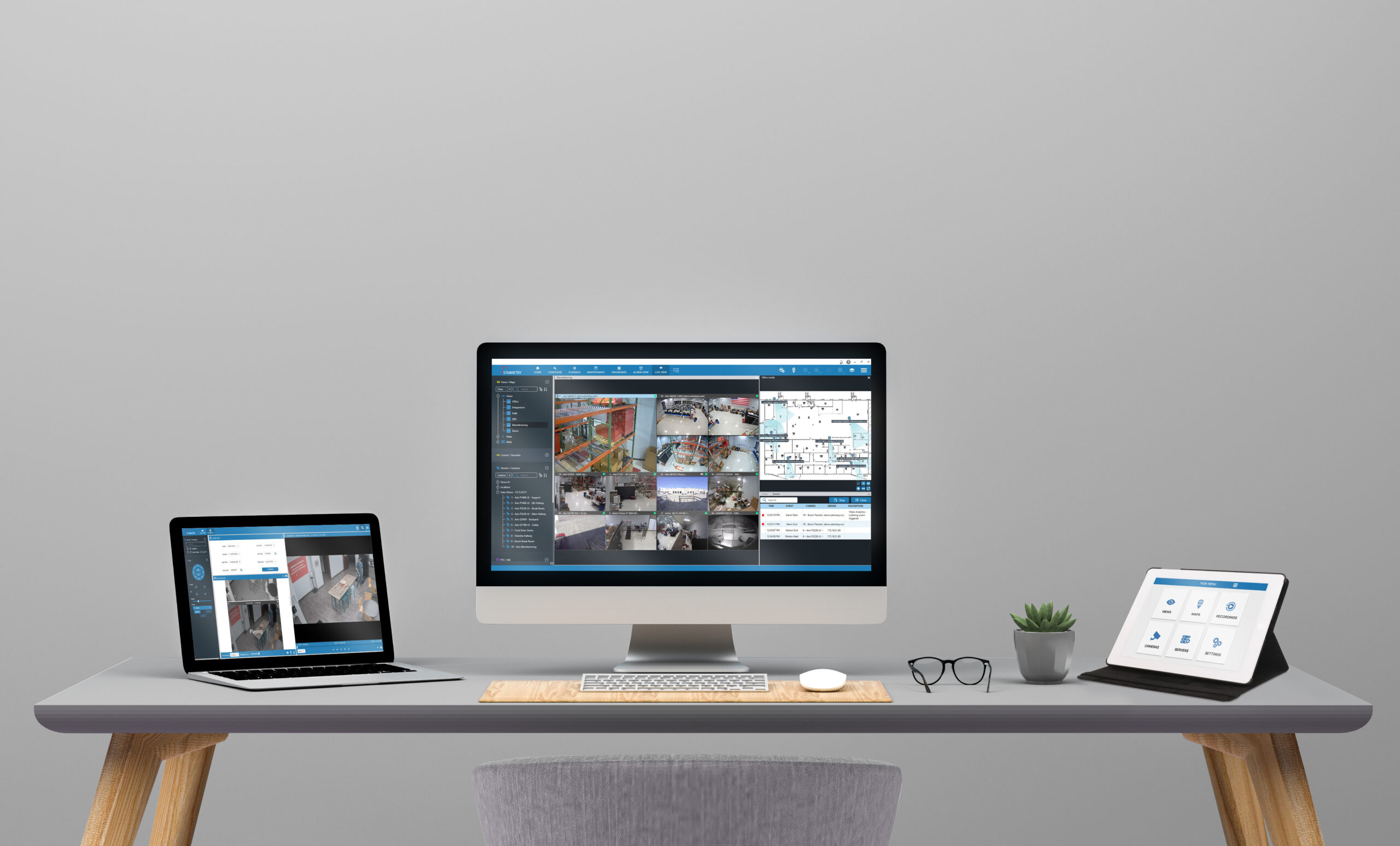 Desk with a laptop, desktop computer, and tablet all open for work